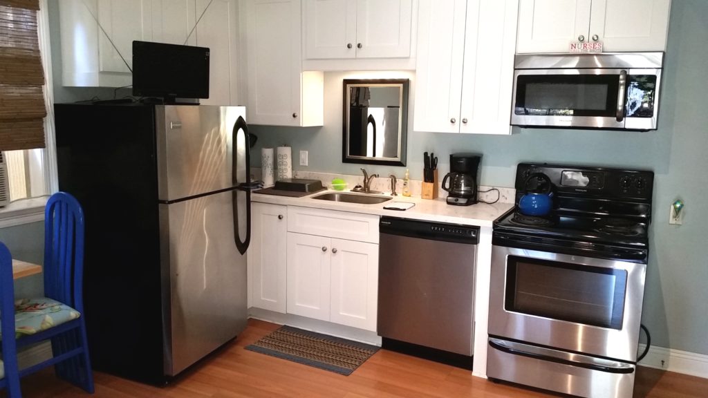 Full kitchen with Stainless Steel appliances and white quartz counter tops.  

Appliances include Frdge / Freezer, Electric Range, Microwave, Dishwasher, Toaster, and Coffee Maker.  Also includes glasses, plates, flatware, and cooking utensils.